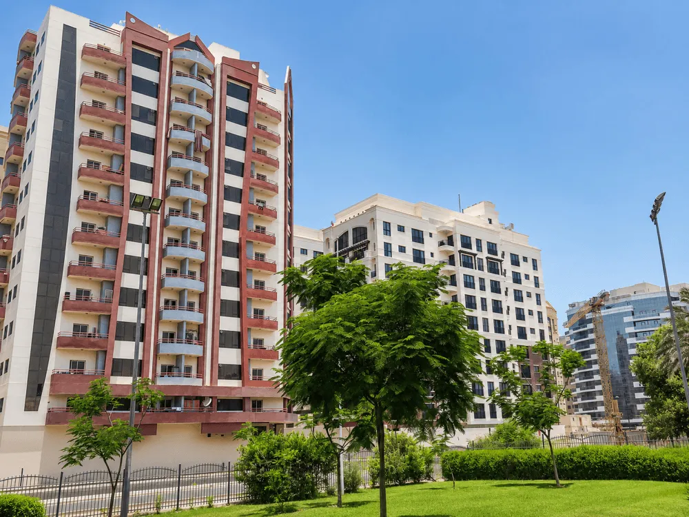 High-rise apartment buildings beside landscaped greenery in Al Nahda, Dubai
