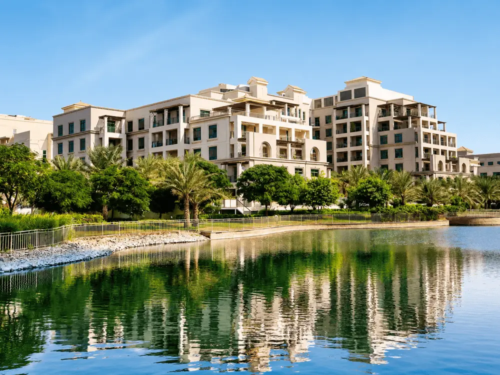 Apartment buildings reflected in a lake in The Greens, Dubai